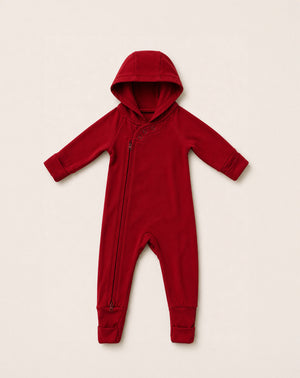 Red baby onesie with a hood on a beige background