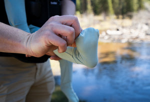 Person adjusting the foot cover over a baby's foot