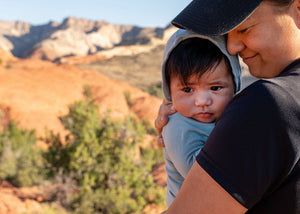 Woman holding a child with mountains in the background