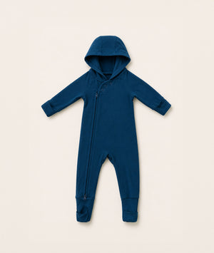 Blue baby onesie with a hood on a beige background