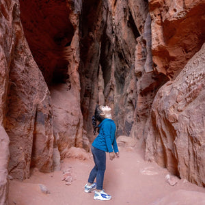 Small child standing in a narrow canyon with red rock walls